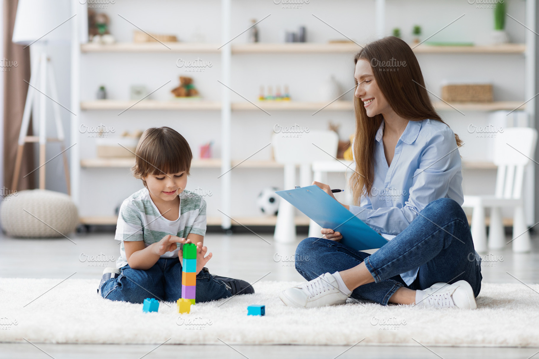 Gentle psychological exam. Professional woman kids specialist watching little p, a Photo by Prostock-Studio