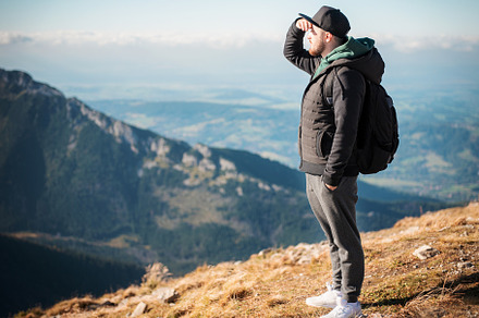 Young man  looking away in front of mountain on sunny day., a Person Photo by Olena Rudo