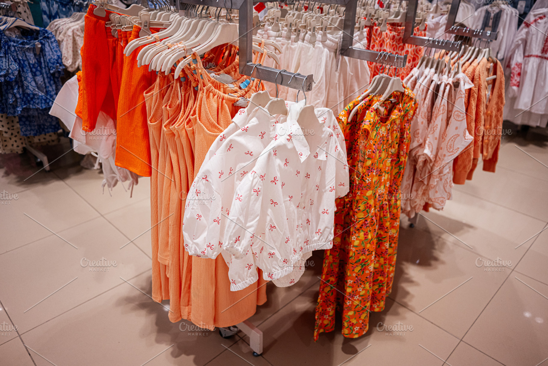 Colorful assortment of children clothing displayed on racks in a retail store, a Photo by AS photostudio