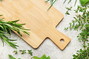 Fresh herbs and empty cutting board lying on kitchen table, a Food & Drink Photo by Olena Rudo
