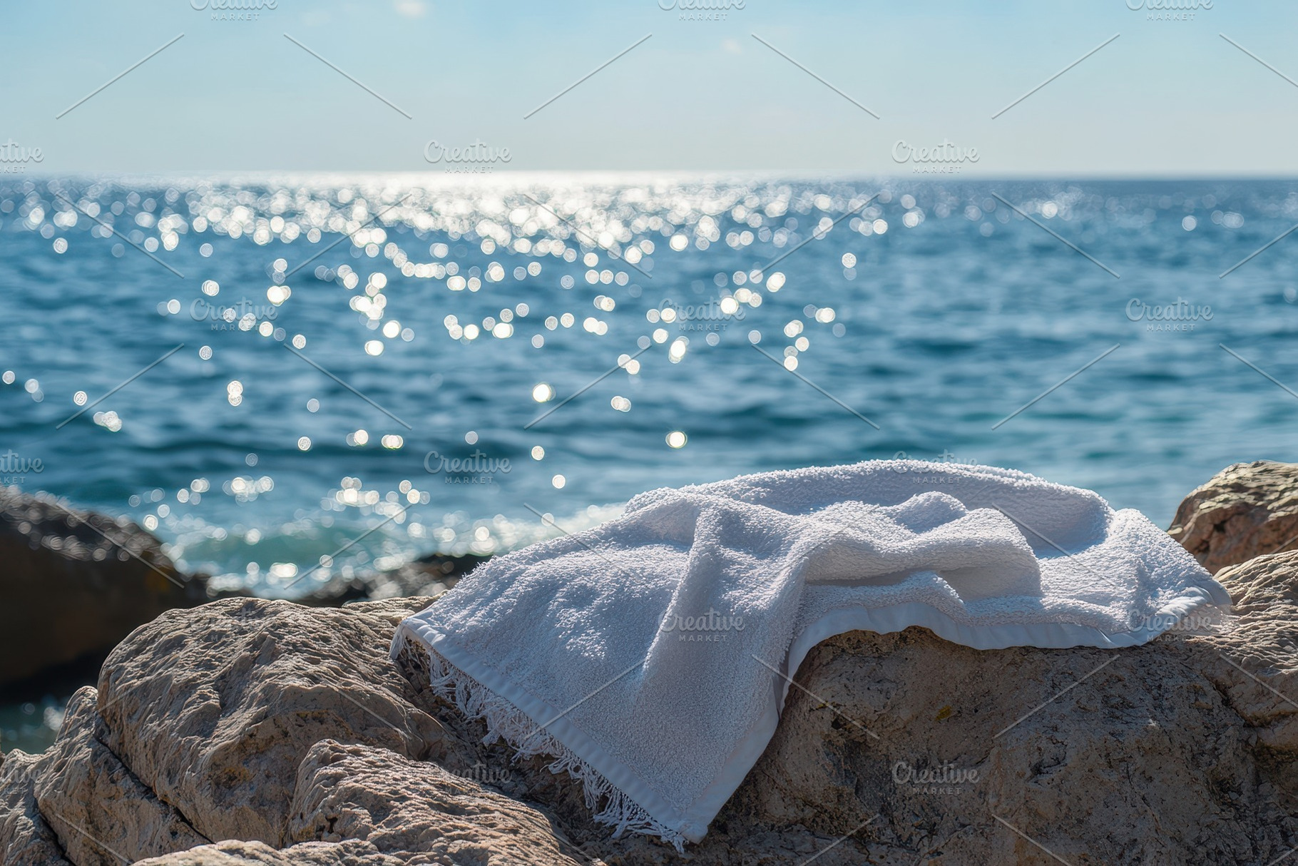 White beach towel resting on sunlit, a Photo by Pavel_design