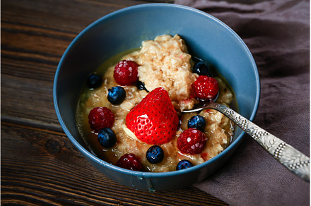 Oatmeal with berries on a wooden, a Food & Drink Photo by sabyna75