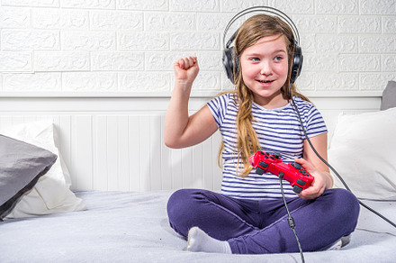 Llittle child kid girl playing video games, a Photo by Rimma