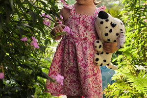 Cute little girl in red toy glasses walking through a blooming summer garden wi, a Photo by Rohan Photography