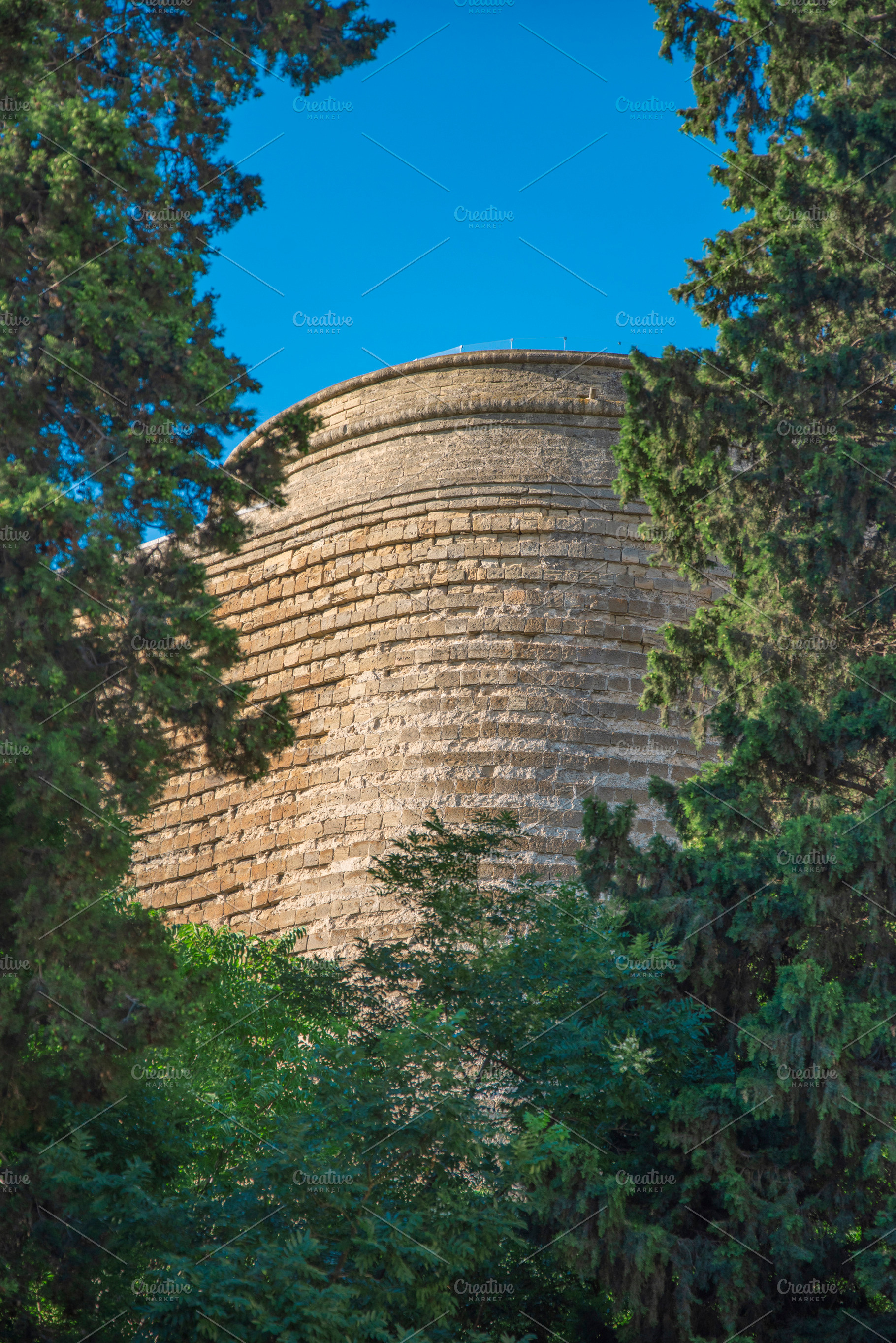 Ancient Maiden Tower in Baku through green trees with copy space, a Photo by Pictures for you!!!!!!!!!