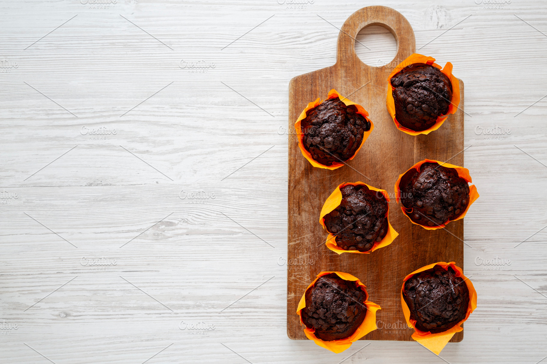 Homemade Chocolate Chip Muffins on a wooden board, top view. Cop, a Food & Drink Photo by LiudmylaChuhunova
