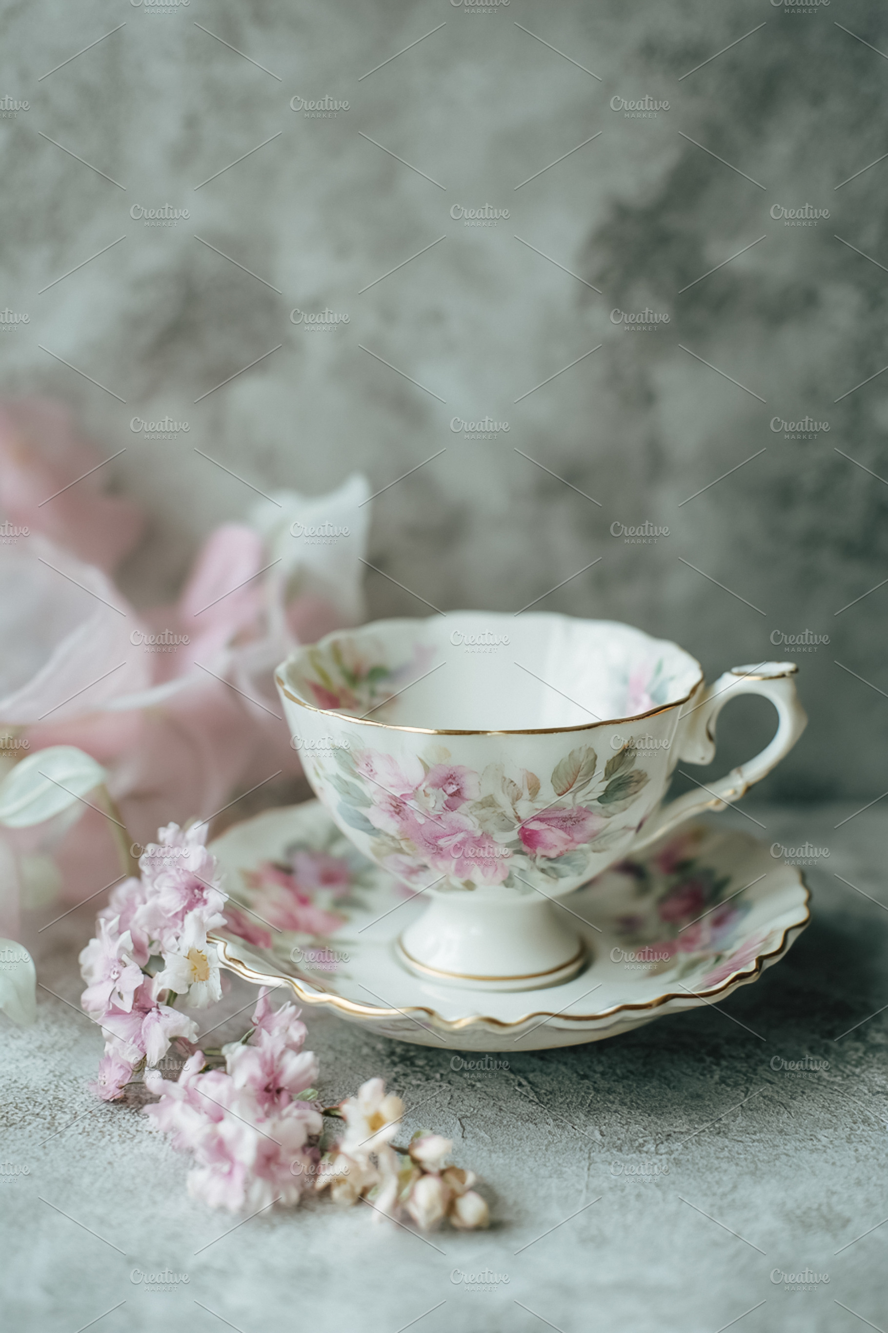 Porcelain tea set with pink floral pattern, gold details, and sm, a Photo by Studio ANNA