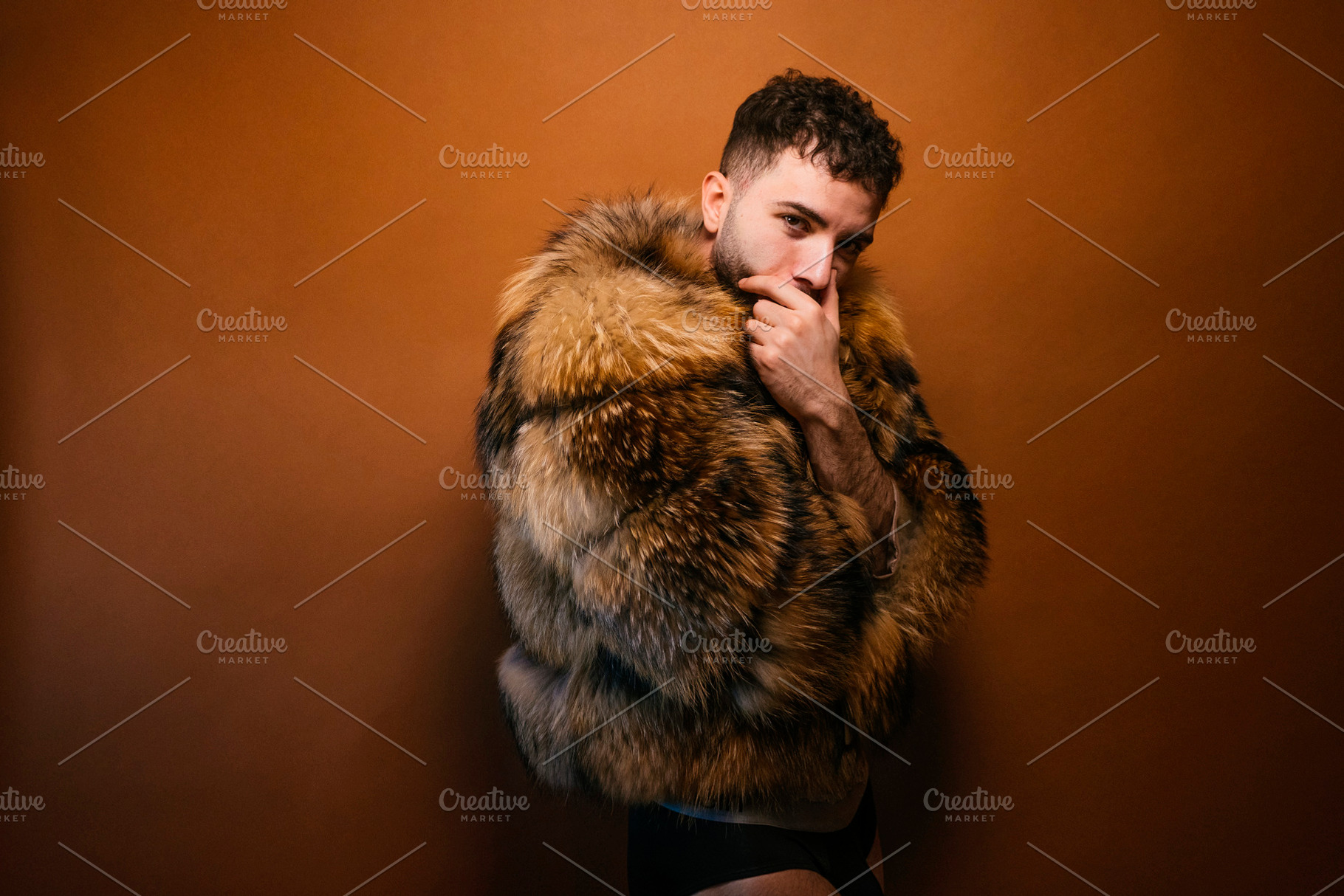 Confident man posing in luxurious fur coat, a Photo by karrastock