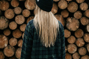 Woman in Beanie Against Log Pile, a Person Photo by Virgo Studio