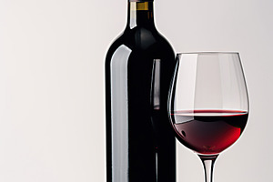 Bottle and glass of red wine on white background, a Food & Drink Photo by AlyaAnd