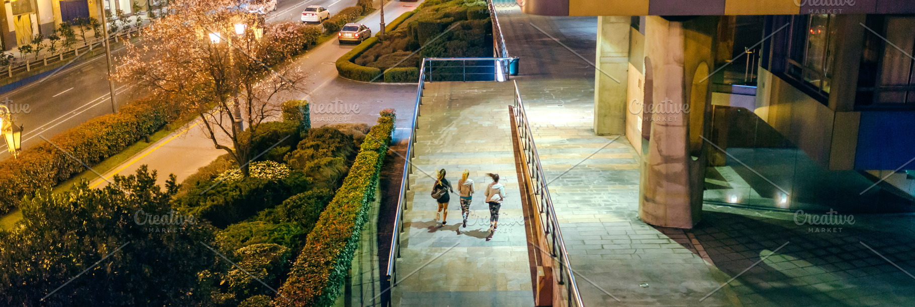 Women friends runners training together on the city at night, a Sports & Recreation Photo by davidpereiras