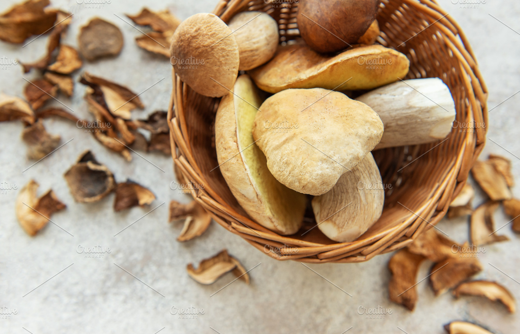 Fresh mushrooms overflowing a small wicker basket with dried mus, a Food & Drink Photo by Olena Rudo