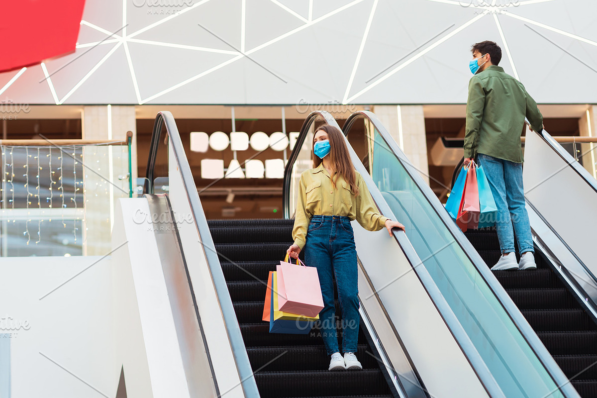 Female And Male Buyers Shopping Standing On Stairs In Mall, a Photo by Prostock-Studio (Photo 1 of 2)