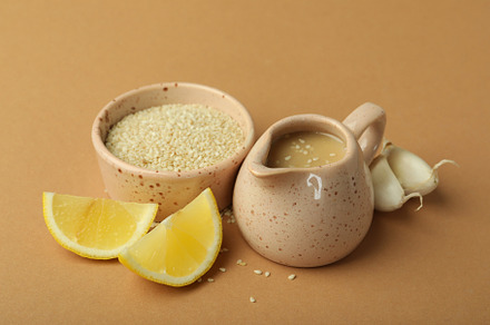 Concept of tasty food with tahini sauce on beige background, a Food & Drink Photo by AtlasStudio PRO