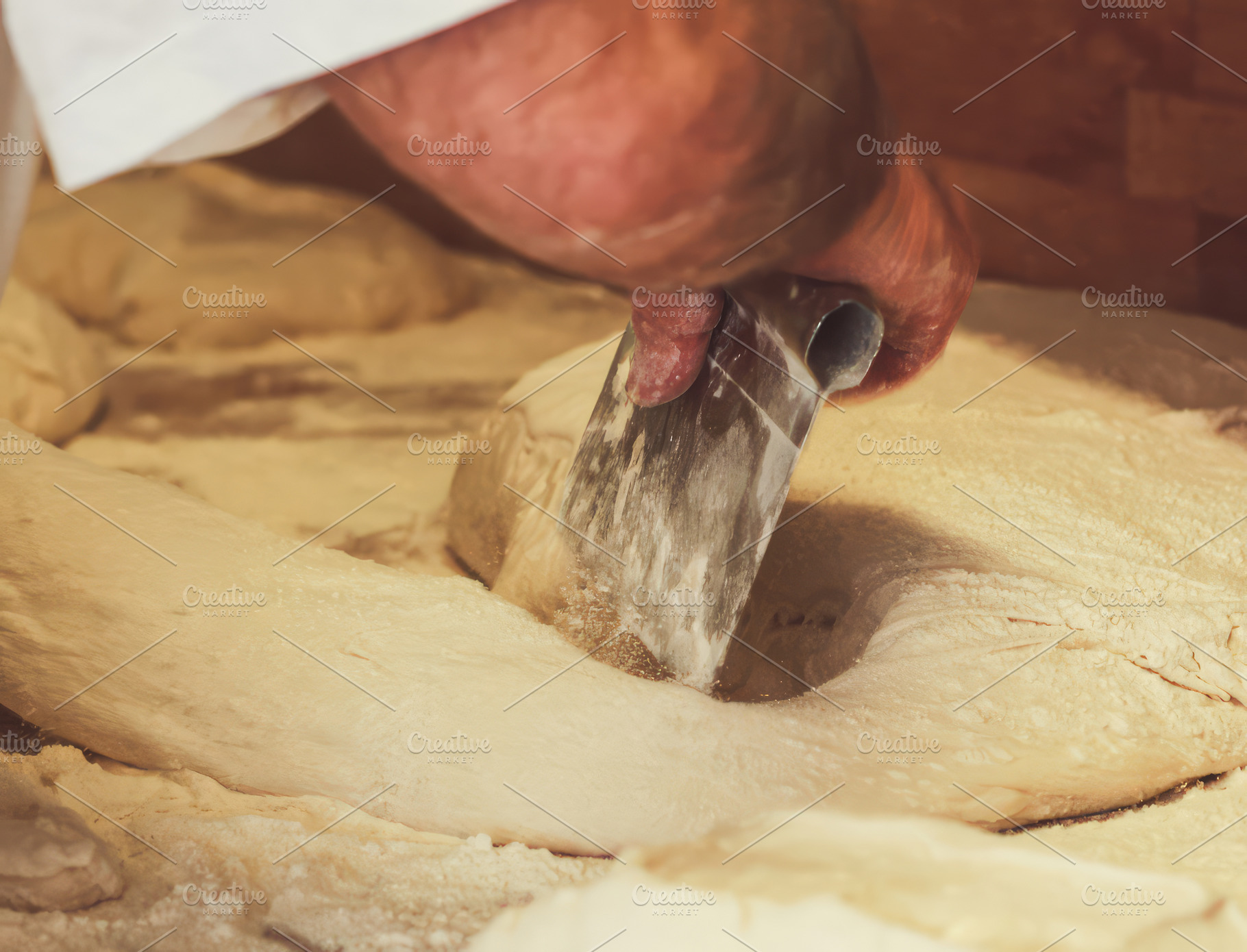 Baker dividing dough with metal scraper in bakery, an Abstract Photo by Antonio Gravante Market
