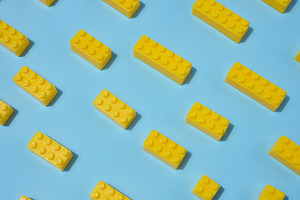 Scattered yellow plastic toy building bricks on a blue backgroun, a School & Education Photo by ndanko