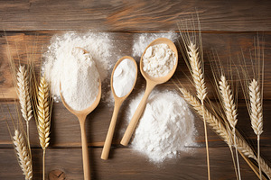 Flour in wooden spoons and wheat ears on wooden background, a Food & Drink Photo by AlyaAnd