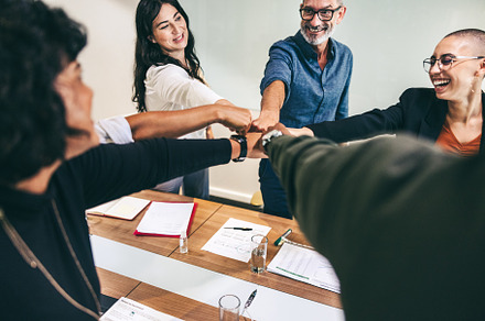 Ecstatic businesspeople bringing their fists together in a boardroom, a Person Photo by Jacob Lund