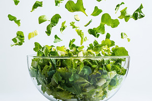 Fresh Green Salad Falling into Glass, a Food & Drink Photo by Pixeness Studio