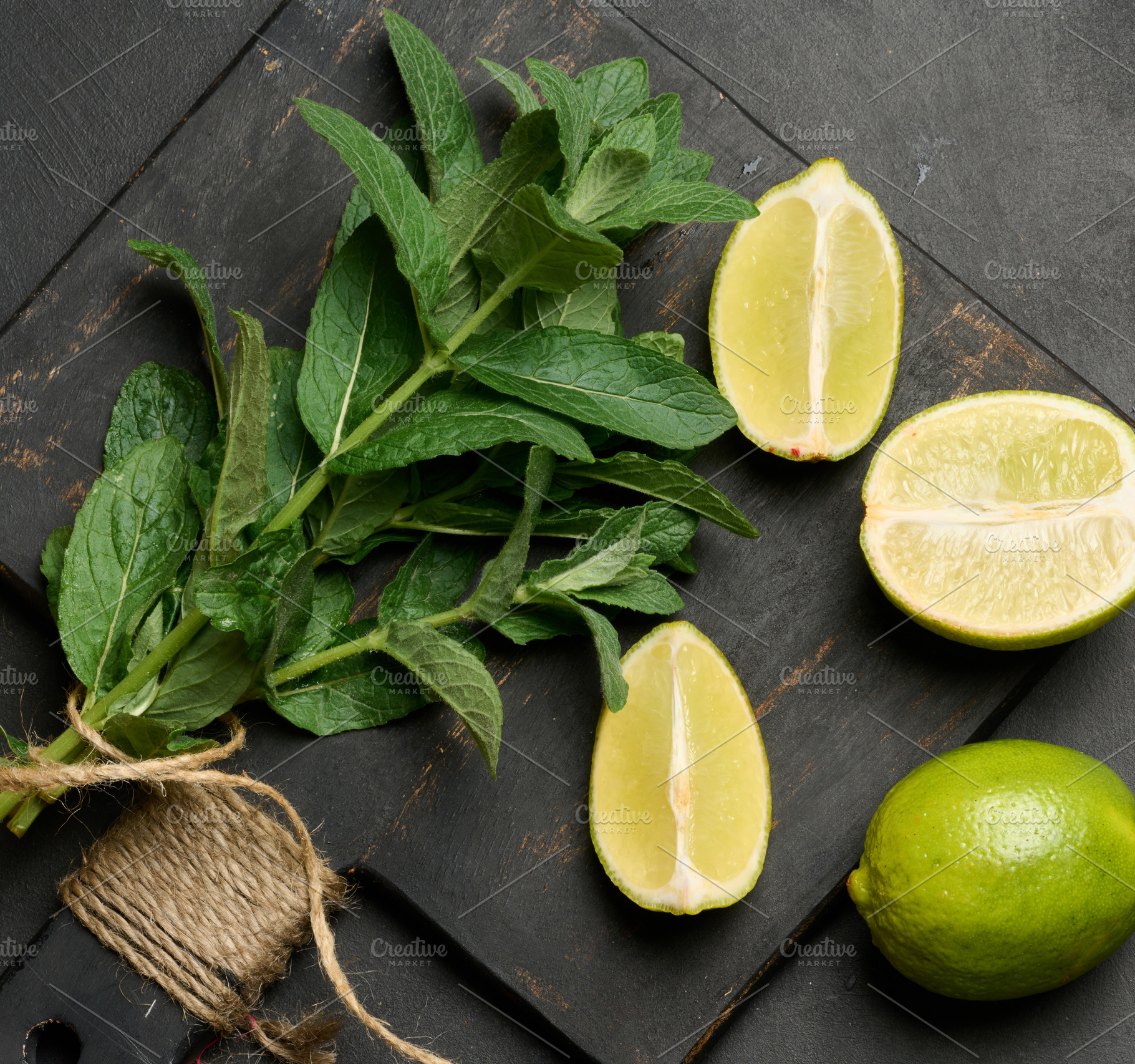 Bunch of fresh green mint on wooden board and lime wedges, top v, a Nature Photo by ndanko
