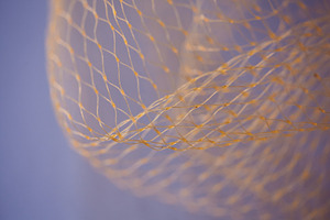 Abstract macro of a golden nylon net against a soft purple background. Flowing, an Abstract Photo by Rohan Photography