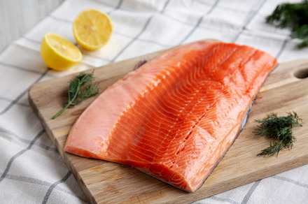 Organic Raw Salmon Fillet on a wooden board, side view., a Food & Drink Photo by LiudmylaChuhunova