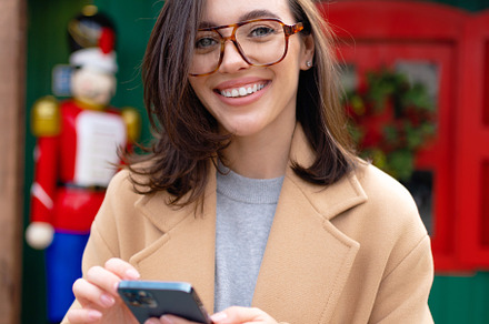 Woman in glasses using mobile phone at day in the city, a Person Photo by andreonegin market