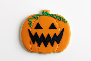 Halloween pumpkin cookie with jack o lantern face isolated on wh, a Food & Drink Photo by José Manuel Gelpi