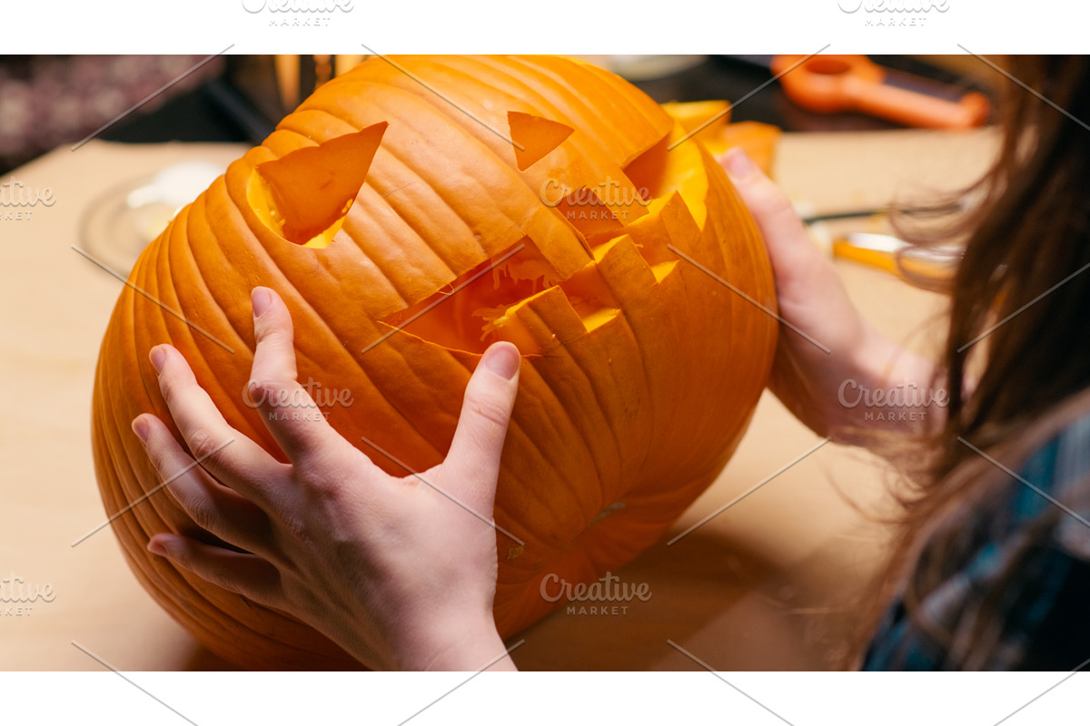 Woman carving Jack O Lantern pumpkin, a Graphic by sergeypeterman