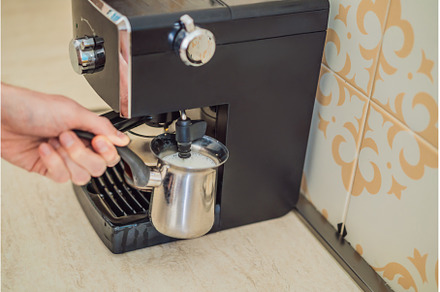 Handsome man using coffee machine in, a Person Photo by Elizaveta Galitskaya