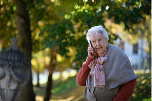 Elderly woman in the park, holding a, a Technology Photo by HalfPoint