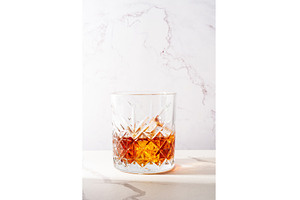 Whiskey with ice cube in the glass, a Food & Drink Photo by Nadia-nb