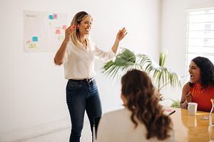 Cheerful businesswoman laughing with her colleagues in a boardro, a Person Photo by Jacob Lund