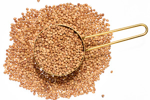 Raw buckwheat grains on isolated background, close up, a Food & Drink Photo by ndanko