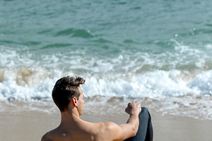 Rear view of a young bared man weari