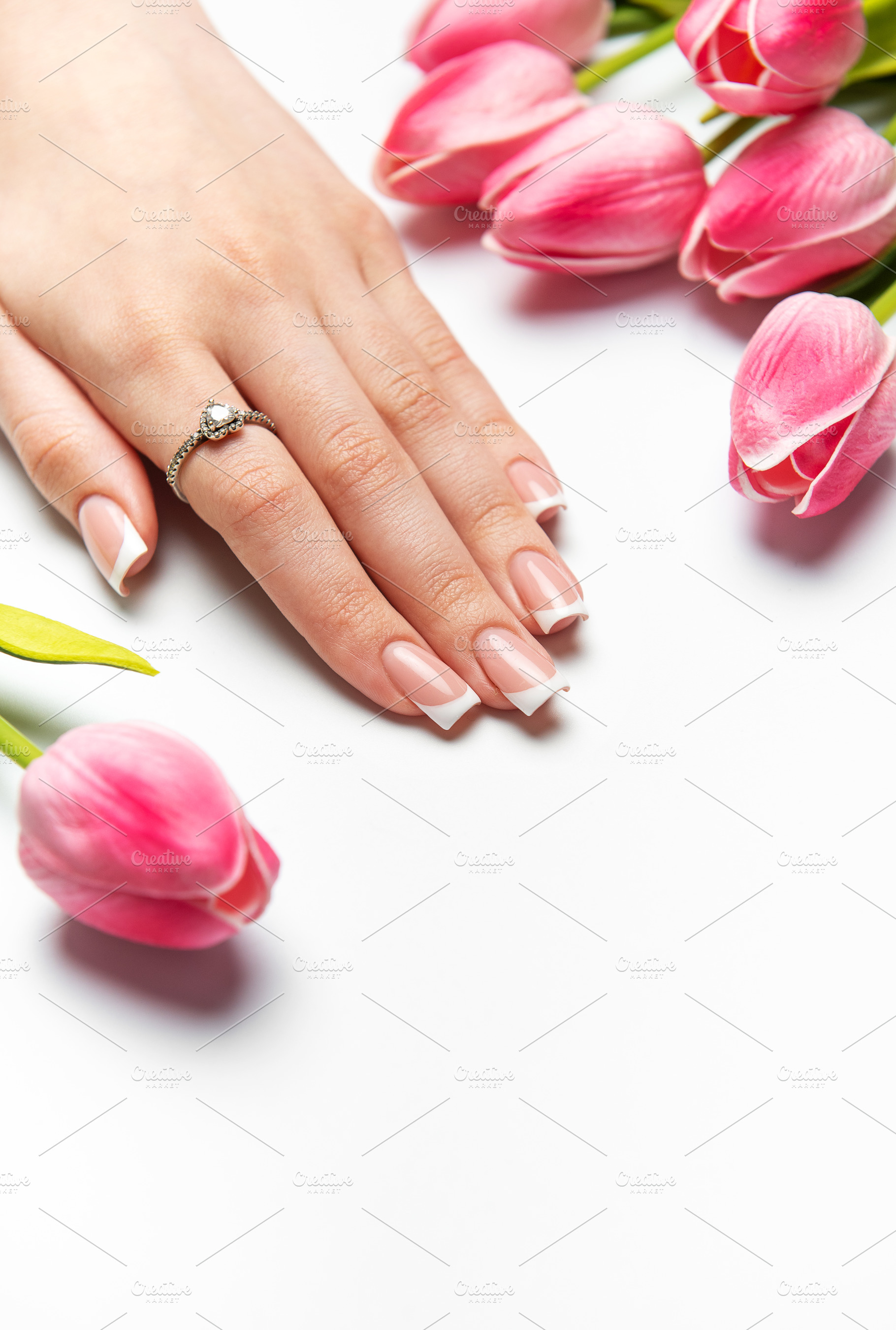 Woman showing french manicure and pink tulips on white backgroun, a Beauty & Fashion Photo by Olena Rudo