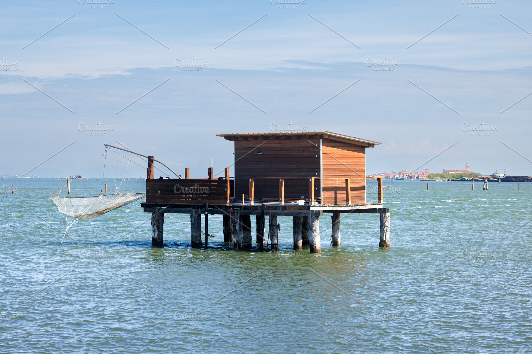 A rustic wooden stilt house and boat with fishing nets, a Nature Photo by Bepslabor
