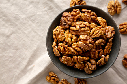 Raw Walnut Halfs in a Bowl, top view. Flat lay, overhead. Copy s