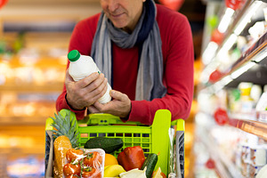 Cropped of customer choosing best dairy products, doing grocery alone, a Photo by Prostock-Studio