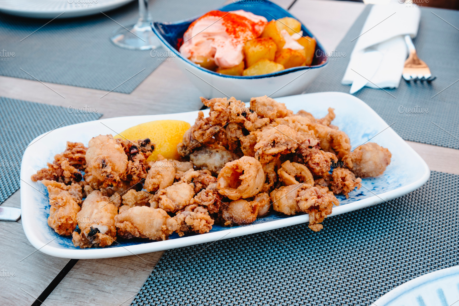 spanish chipirones and patatas bravas on a table, a Photo by Nito