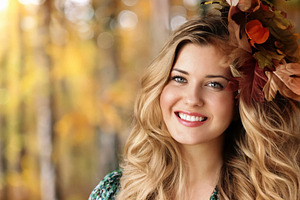 Young woman with autumn leaves in her hair smiling, portraying b, a Person Photo by Studio ANNA