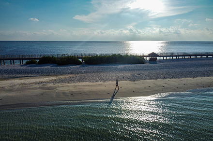 Solitary woman walking on a Maldives beach, a Person Photo by Cosca