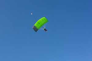 A paraglider with a green parachute is descending down to Kanin, Slovenia,, a Sports & Recreation Photo by Bepslabor