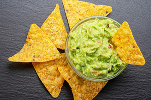 Guacamole sauce and tortilla chips, popular Mexican food, on sla, a Food & Drink Photo by Volff