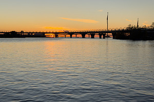 A serene river scene at sunset, featuring a bridge in the background and colorf, a Nature Photo by Textures & Backgrounds