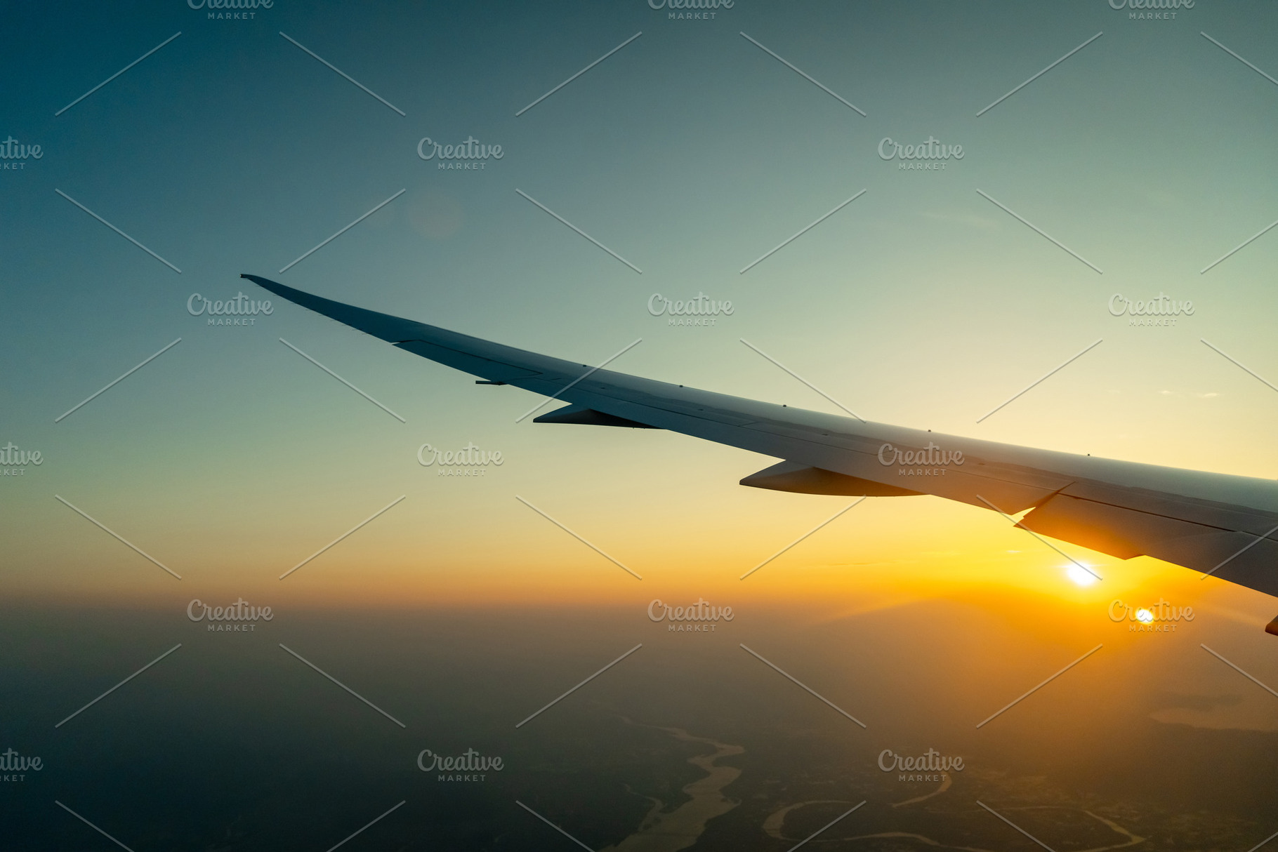Airplane wing above Osaka coast during sunset descent flight, a Transportation Photo by GoodGoods