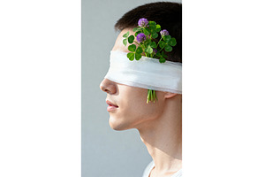Man blindfolded with clover flowers, a Nature Photo by tilialucida