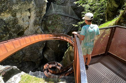 Young person explores scenic canyon walkway on sunny day in Liechtensteinklamm,, a Photo by AS photostudio