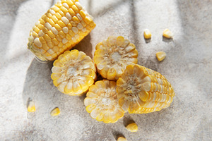 Fresh corn cobs with kernels on gray background, a Food & Drink Photo by Olena Rudo