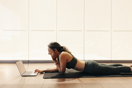 Happy senior woman joining an online yoga class on a laptop, a Person Photo by Jacob Lund